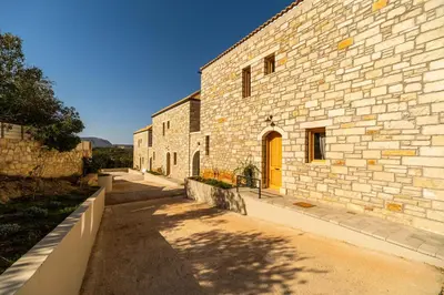 a brick building with a yellow door on it at Villa Falcos by PosarelliVillas in Gavalochori