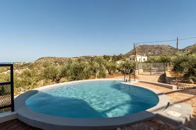 a swimming pool in a yard with mountains in the background at Villa Seiri by PosarelliVillas in Gavalochori