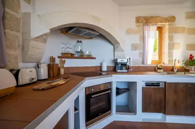 a kitchen with a counter with a sink and an oven at Villa Lavidona by PosarelliVillas in Gavalochori