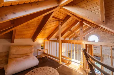 an attic room with a couch and a window at Villa Lavidona by PosarelliVillas in Gavalochori