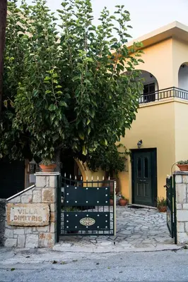 a gate in front of a house with a tree at Villa Dimitris in Kalamitsi Amygdali