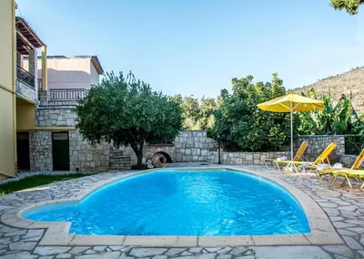 a swimming pool with chairs and an umbrella at Villa Dimitris in Kalamitsi Amygdali