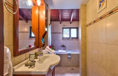 a bathroom with a sink and a bath tub at Villa Olive Xrisi in Kafoúros