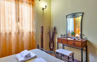 a bedroom with a bed and a vanity with a mirror at Villa Olive Xrisi in Kafoúros