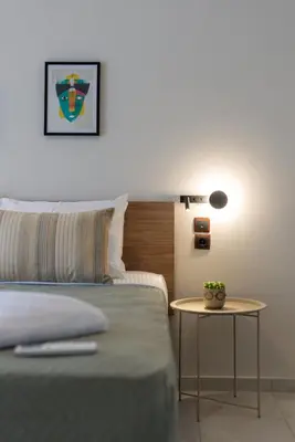 a bedroom with a bed and a table with a lamp at Chania Experience Residence in Chania Town