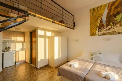a bedroom with two beds and a kitchen at Ilios Mare Hotel in Agia Marina Nea Kydonias