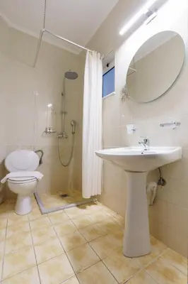 a bathroom with a sink and a toilet and a mirror at Ilios Mare Hotel in Agia Marina Nea Kydonias