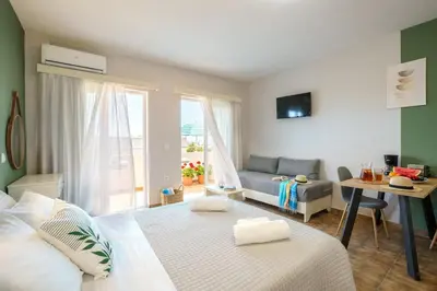 a bedroom with a bed and a living room at Ilios Mare Hotel in Agia Marina Nea Kydonias