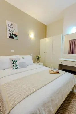 a large white bed in a room with a piano at Ilios Mare Hotel in Agia Marina Nea Kydonias
