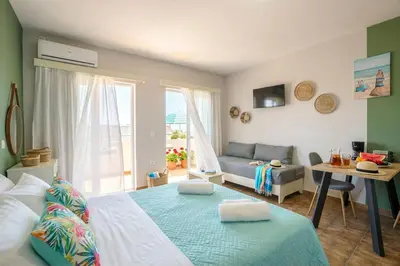 a bedroom with a bed and a living room at Ilios Mare Hotel in Agia Marina Nea Kydonias