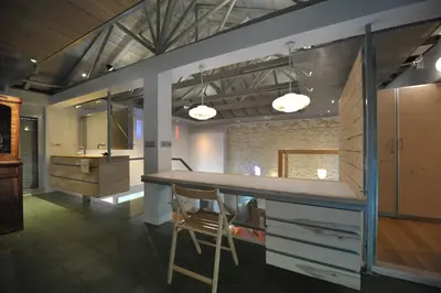 a kitchen with a counter and a bar with two chairs at The Architect's House in Neo Chorio in Néon Khoríon