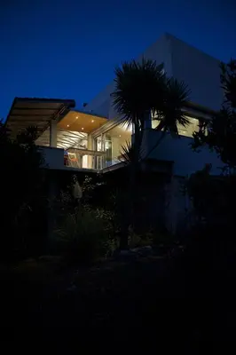 a house at night with a palm tree in front of it at The Architect's House in Neo Chorio in Néon Khoríon