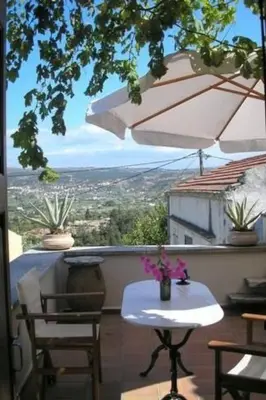 a table and chairs on a balcony with an umbrella at Holiday Home in Douliana mit Großem Balkon by Interhome in Douliana