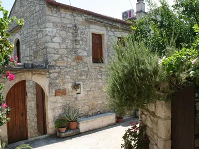 an old stone house with a wooden door and some plants at Holiday Home in Douliana mit Großem Balkon by Interhome in Douliana