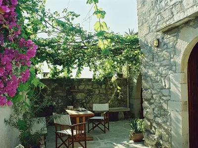 a patio with a table and chairs and flowers at Holiday Home in Douliana mit Großem Balkon by Interhome in Douliana