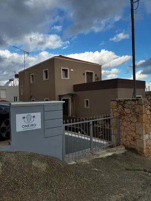 a house with a gate in front of a building at Oneiro Apartment in Kounoupidhianá