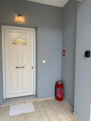a white door in a room with a fire extinguisher at Oneiro Apartment in Kounoupidhianá