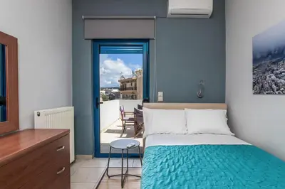 a bedroom with a bed and a view of a balcony at Kafkales Penthouse Chania Old Town in Chania Town