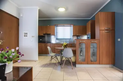 a kitchen with wooden cabinets and a table and chairs at Kafkales Penthouse Chania Old Town in Chania Town
