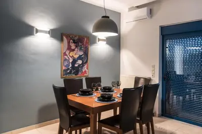 a dining room with a wooden table and black chairs at Kafkales Penthouse Chania Old Town in Chania Town