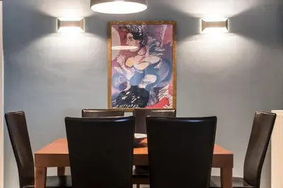 a dining room with a table and a painting on the wall at Kafkales Penthouse Chania Old Town in Chania Town