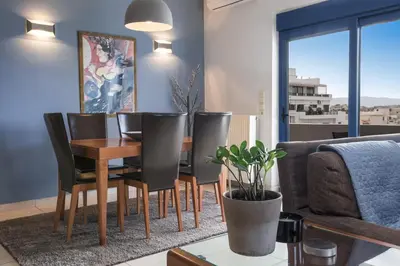 a dining room with a table and chairs and a couch at Kafkales Penthouse Chania Old Town in Chania Town