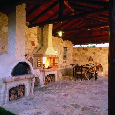 an outdoor patio with a large stone fireplace at Dream Hill Villas in Tavronitis