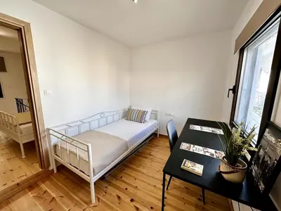 a small room with a bed and a table at Nomas Home, Kalyves Centre Beachfront Sea View in Kalyves