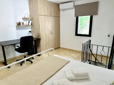 a bedroom with a bed with a desk and a chair at Nomas Home, Kalyves Centre Beachfront Sea View in Kalyves