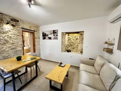 a living room with a couch and a table at Nomas Home, Kalyves Centre Beachfront Sea View in Kalyves