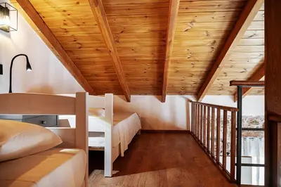 a bedroom in a house with wooden ceilings at To Petrino Stone Mountain Retreat with Private Pool in Rodhopós
