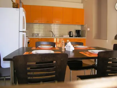 a kitchen with a table with chairs and a refrigerator at 3-Min Drive to Kalyves Beach, Stone Villa in Armenoi next to Cafés & Taverns by the Natural Water Springs in Arménoi