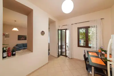 a living room with a table and a dining room at 3-Min Drive to Kalyves Beach, Stone Villa in Armenoi next to Cafés & Taverns by the Natural Water Springs in Arménoi