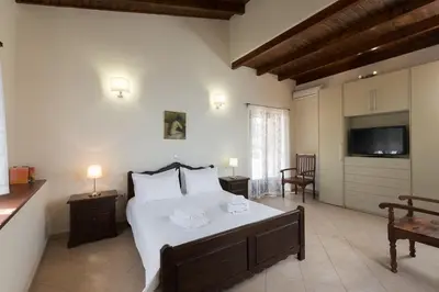 a bedroom with a large bed and a television at 3-Min Drive to Kalyves Beach, Stone Villa in Armenoi next to Cafés & Taverns by the Natural Water Springs in Arménoi