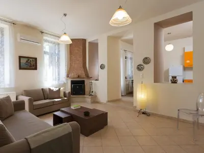 a living room with a couch and a table at 3-Min Drive to Kalyves Beach, Stone Villa in Armenoi next to Cafés & Taverns by the Natural Water Springs in Arménoi