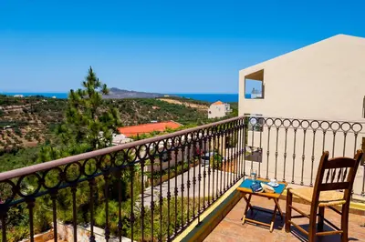 a balcony with a chair and a table on it at Villa Eftichia in Stalos