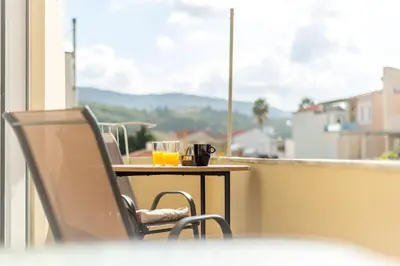 a balcony with a table with two glasses of orange juice at Cozy Apartment Next To The Beach In Almyrida -BY APOKORONAS VILLAS in Almirida
