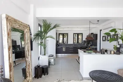 a kitchen and living room with a large mirror at Villa EsHi w Private Pool & Scenic Sea View in Kalyves