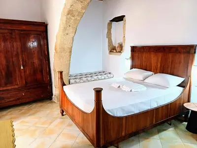 a bedroom with a large wooden bed with white pillows at Violetta Kaliviani room 1 in Kalivianí
