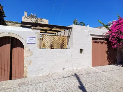 a white building with two doors and a window at Violetta Kaliviani room 1 in Kalivianí