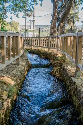 a small stream with a wooden fence next to it at Traditional Art House Armenoi in Arménoi