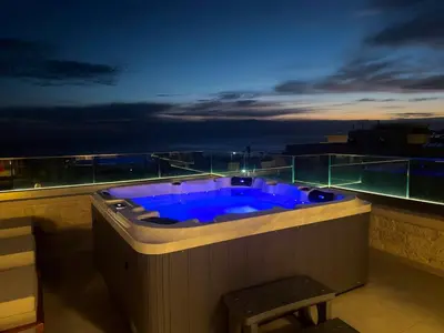a jacuzzi tub on a balcony at night at Cozy Suite Palaiochora Sea View, Jacuzzi, Top WiFi in Palaiochóra