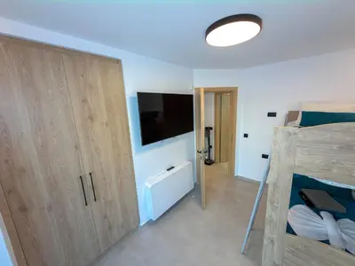 a bedroom with a bunk bed and a flat screen tv at Cozy Suite Palaiochora Sea View, Jacuzzi, Top WiFi in Palaiochóra