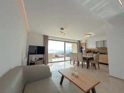 a living room with a couch and a table at Cozy Suite Palaiochora Sea View, Jacuzzi, Top WiFi in Palaiochóra