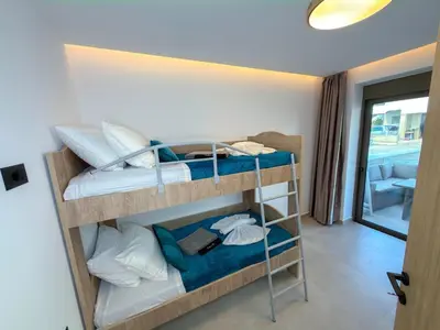 a room with three bunk beds in a room at Cozy Suite Palaiochora Sea View, Jacuzzi, Top WiFi in Palaiochóra