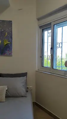 a bedroom with a bed and a window at John's TownHouse Chania in Tsikalariá