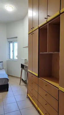 a bedroom with a bed and a dresser and a desk at John's TownHouse Chania in Tsikalariá