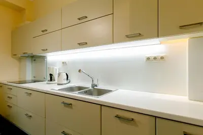 a kitchen with white cabinets and a sink at Leda's Nea Chora Flat, Near Beach and Old Port in Chania Town
