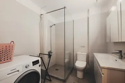 a bathroom with a toilet and a glass shower at Leda's Nea Chora Flat, Near Beach and Old Port in Chania Town