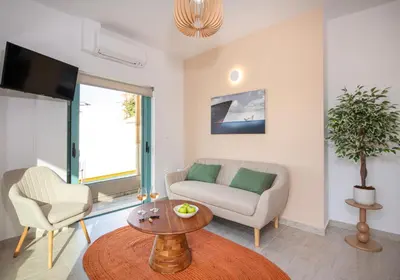 a living room with a couch and a table at KHORA Apartment- 40m to Sandy Beach in Chania Town